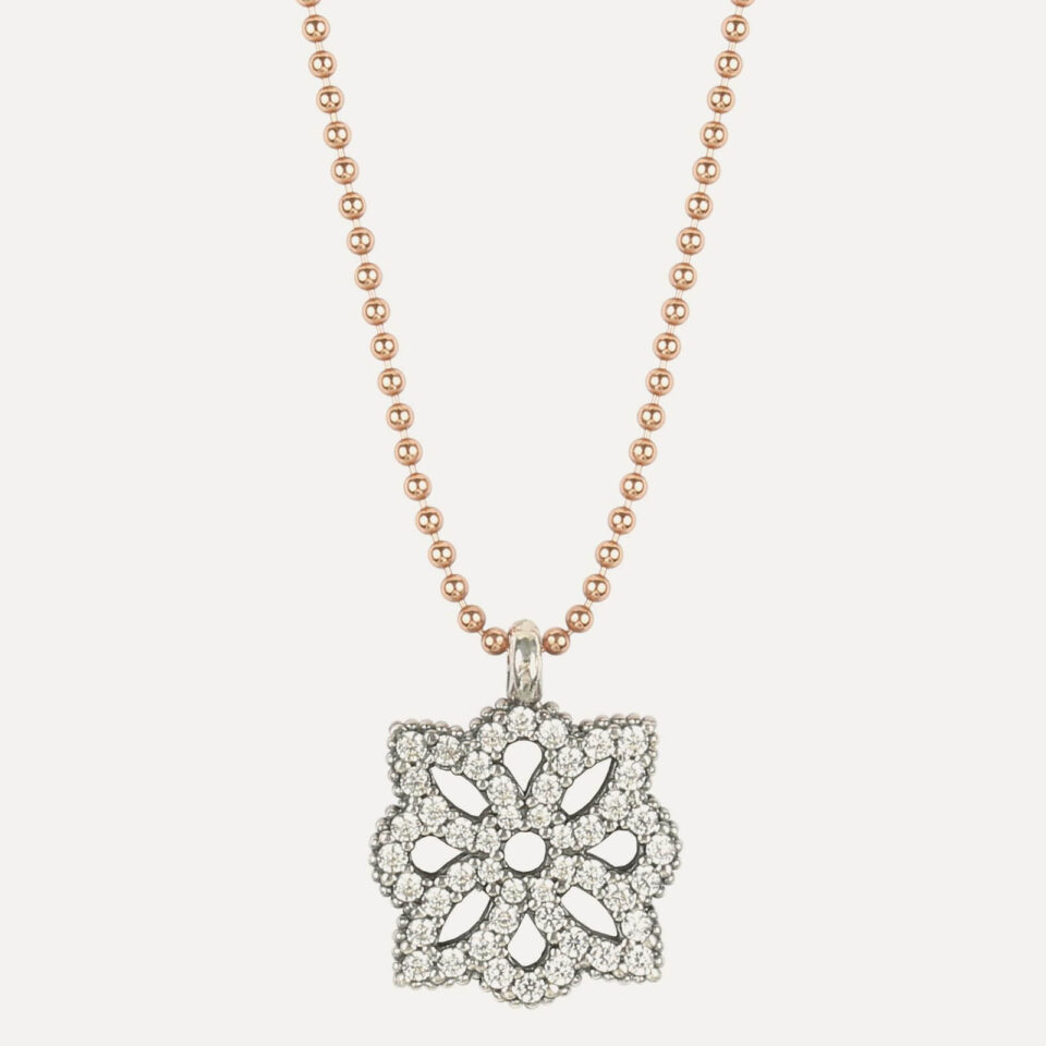 El COLLAR SUNFIELD CL064502 es de plata con circonitas talla brillante engastadas a mano, creando forma de flor. Cadena de plata con baño de oro rosa 18kt.