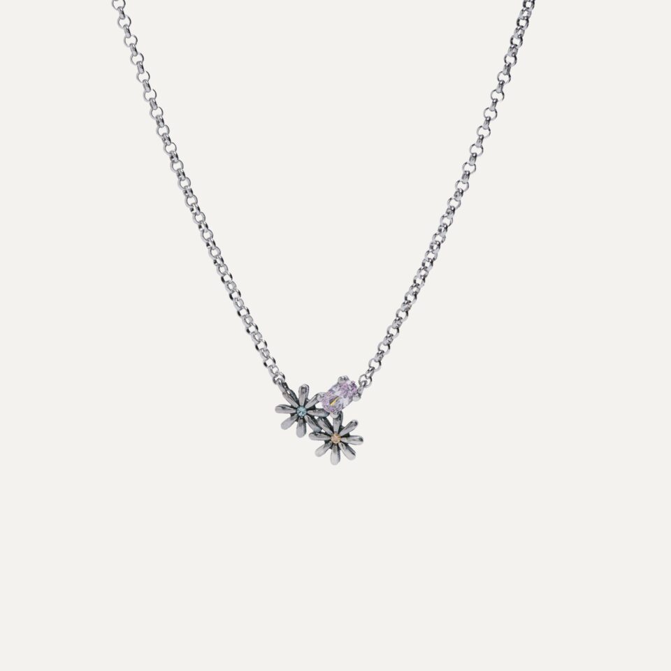 con motivo floral y circonita talla brillante. Su diseño muestra una circonita amatista central en otra talla engastada. La cadena es de plata